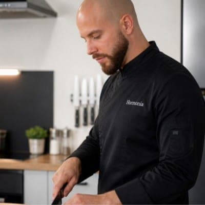 Jordan, chef, en veste Hormonia, en train de travailler dans sa cuisine.
